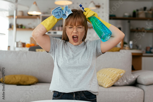 Fotografia Sad woman cleaning home. Young tired woman at home.