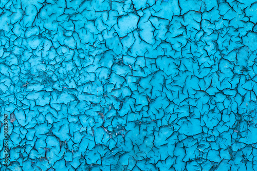 background of an old cracked oily blue paint under the influence of atmospheric phenomena. Close-up texture.