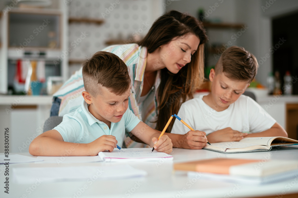 Mother helping her son with homework at home. Little boy learning at home.. Mother helping her son with homework at home. Little boy learning at home..