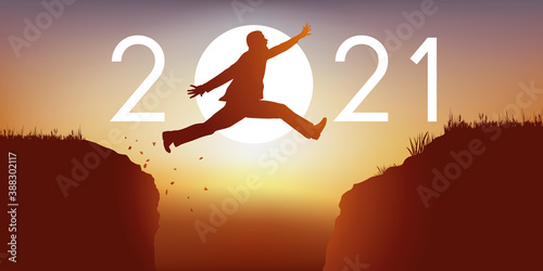 Un homme saute par dessus un gouffre entre deux falaises devant un soleil au zénith et symbolise le passage à la nouvelle année 2021.
