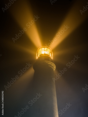 lighthouse on in a foggy night