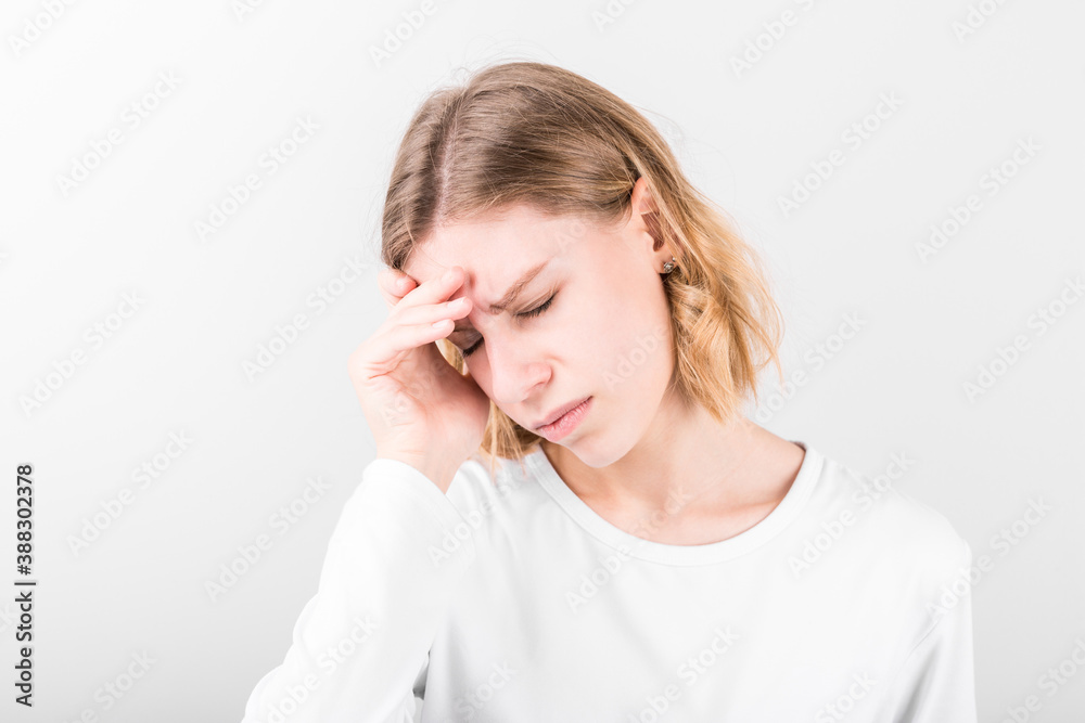 Portrait of beautiful young woman touching her temples feeling stress, on gray background Portrait of beautiful young woman touching her temples feeling stress, on gray background