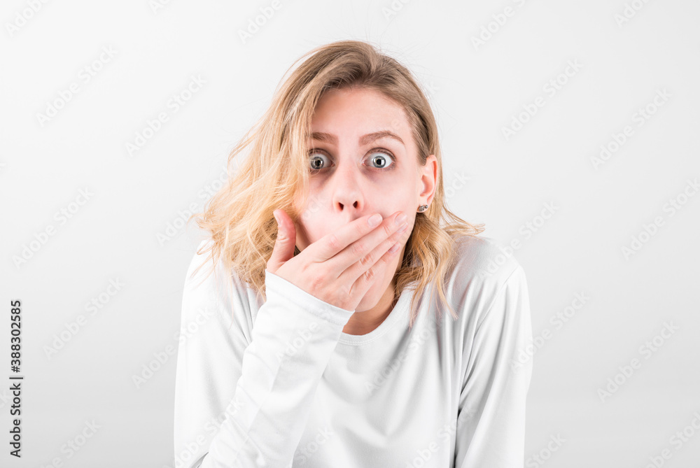 Portrait of a surprised beautiful girl covering her mouth with her hand in wow effect Portrait of a surprised beautiful girl covering her mouth with her hand in wow effect