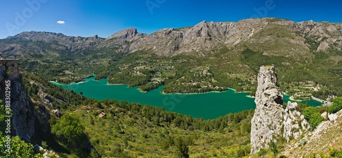 Beautiful view from Guadalest village: a valley with a turquoise reservoir (or lake) and a dam in the mountains. Province of Alicante, Spain.