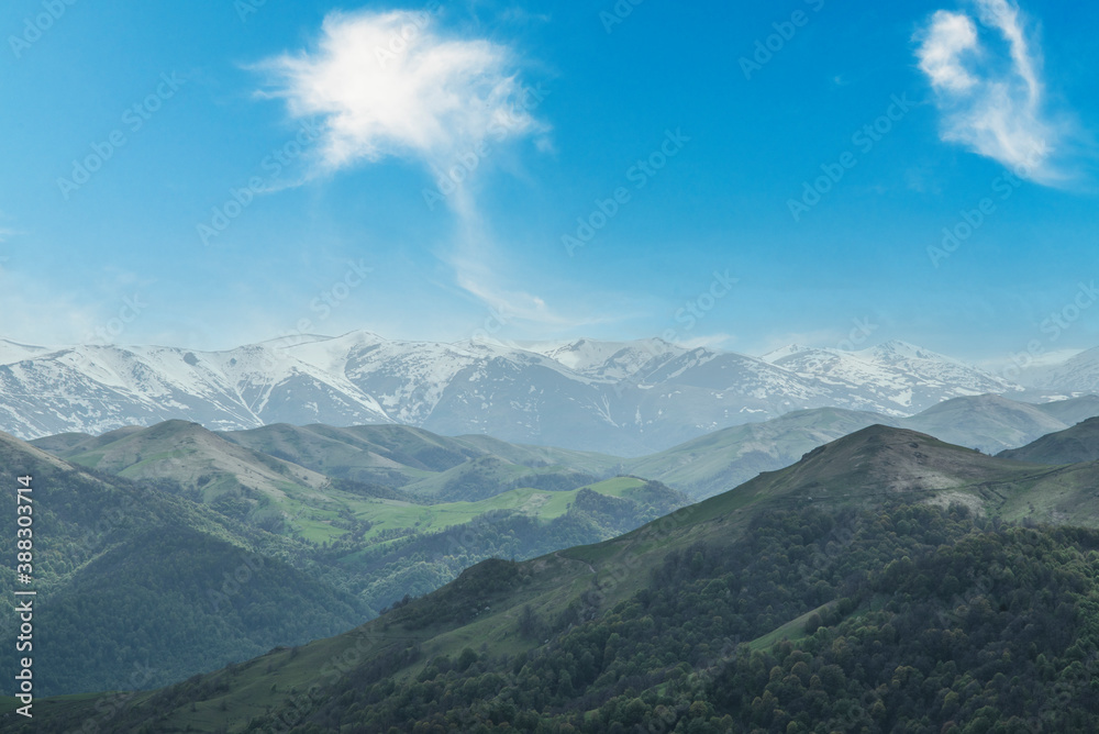 Beautiful mountains landscape with snow peaks and blue sky.