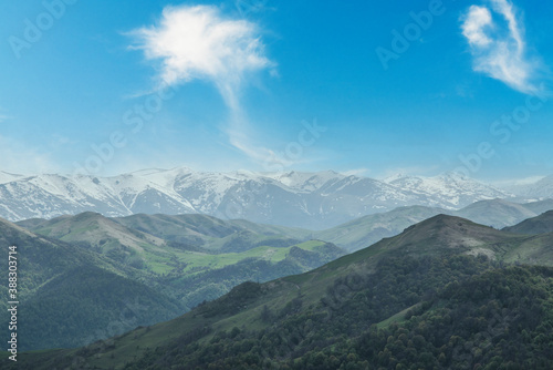 Beautiful mountains landscape with snow peaks and blue sky.