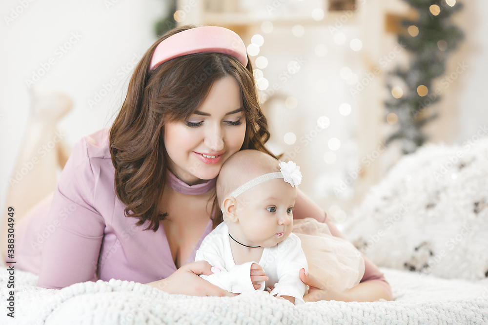 Young mother and her little baby daughter on christmas background Young mother and her little baby daughter on christmas background