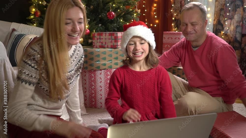 A happy couple with a child is celebrating Christmas with their friends using a video call. Family greeting your relatives on Christmas eve online. Social distancing, self isolation during quarantine A happy couple with a child is celebrating Christmas with their friends using a video call. Family greeting your relatives on Christmas eve online. Social distancing, self isolation during quarantine