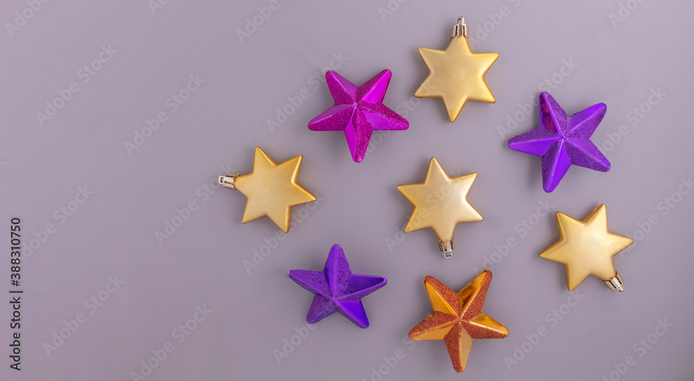 Obraz premium Colorful Christmas stars on a gray background. Banner of decorative elements