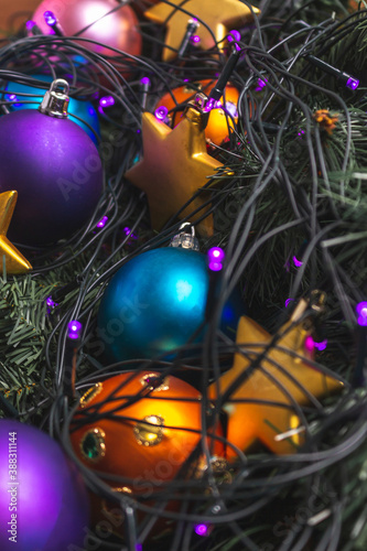 Detail of Christmas balls and stars among Christmas lights and pine