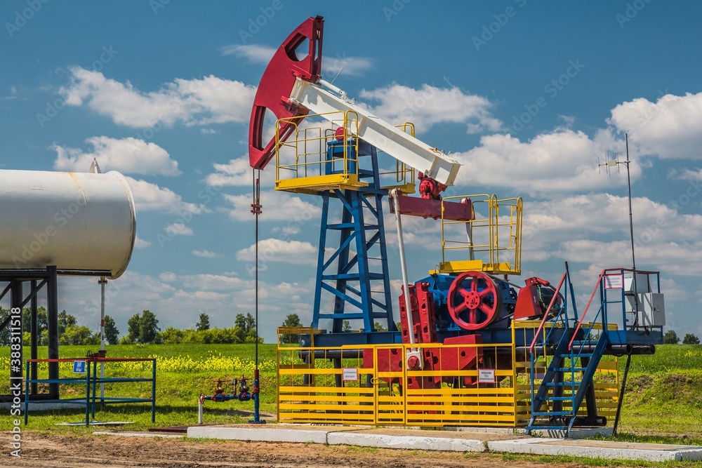 ULYANOVSK, RUSSIA - JUNE 30, 2017: Oil pump with blue sky on the background. Oil field in Ulyanovsk region. Summer. ULYANOVSK, RUSSIA - JUNE 30, 2017: Oil pump with blue sky on the background. Oil field in Ulyanovsk region. Summer.