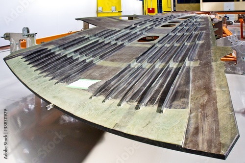 Assembling the airplane. A closeup of part of the plane - wing - in the assembly shop (hall).