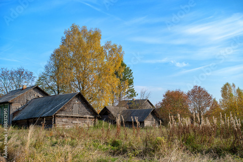 Foto Old, ramshackle village houses among dry, autumn grass