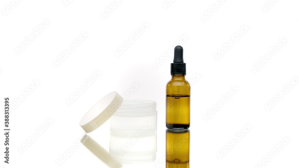 Transparent bottle and jar cosmetic liquids rotating on white background. Moisturizing body oil, natural ingredients plant based preservatives, skin hand nail care cream in motion. Beauty concept Transparent bottle and jar cosmetic liquids rotating on white background. Moisturizing body oil, natural ingredients plant based preservatives, skin hand nail care cream in motion. Beauty concept