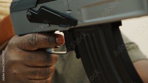 Concept of terrorism. Rebel soldier aiming at targets with an AK-47 machine gun. Close up. High quality photo