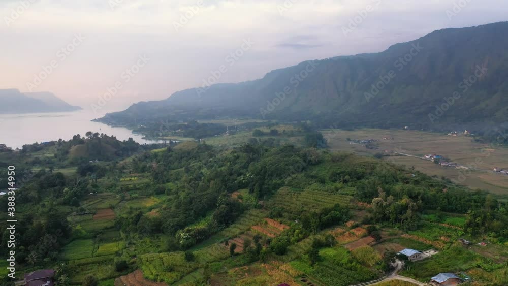 Aerial shot flying over plantations and fields below big hills on Samosir Island in Lake Toba in North Sumatra, Indonesia Aerial shot flying over plantations and fields below big hills on Samosir Island in Lake Toba in North Sumatra, Indonesia