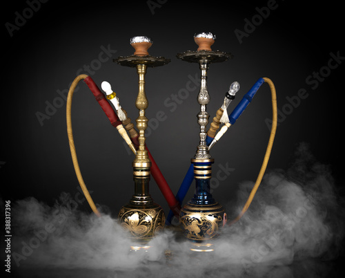 East smoking hookah. Arabian shisha. dark background with smoke