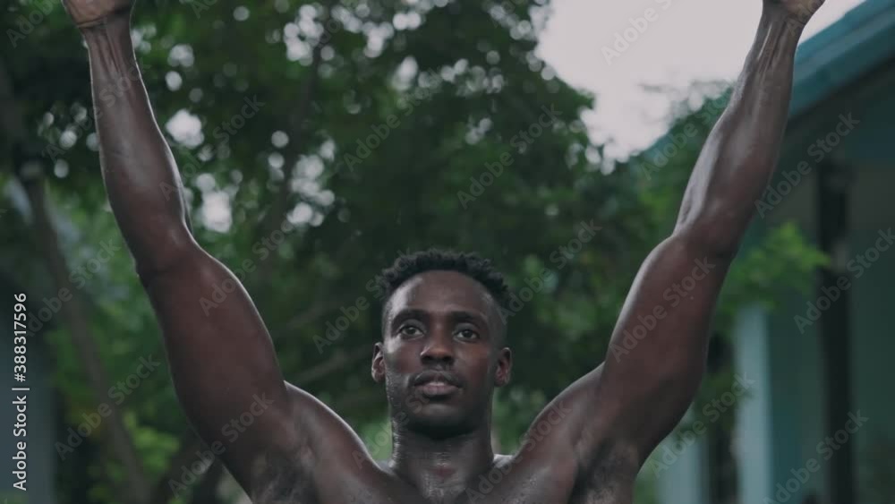 Young african american fit man doing pull-ups at an outdoor gym park Young african american fit man doing pull-ups at an outdoor gym park