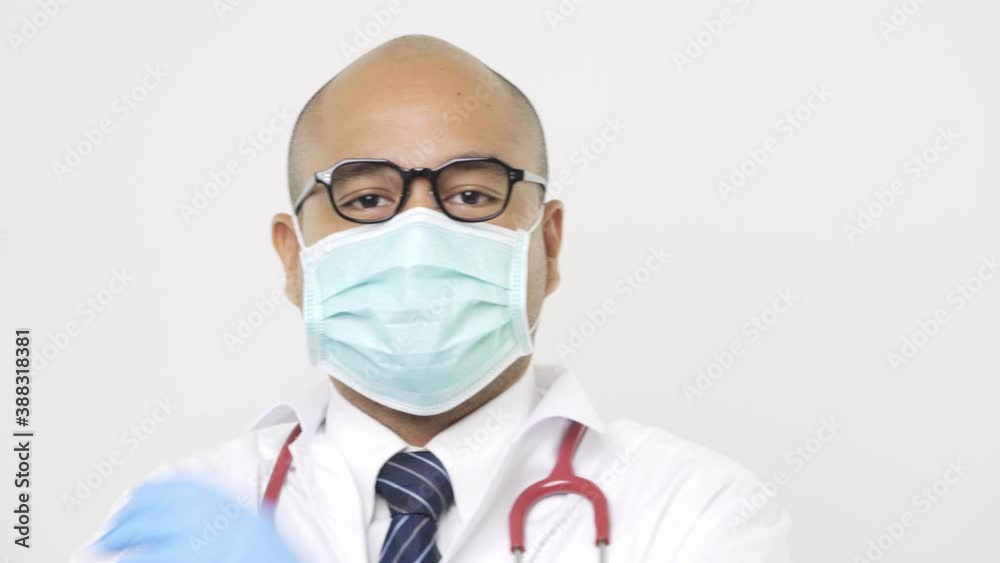 Young asian doctor in uniform put on glasses wearing a face mask, stethoscope cross his arms on isolated white background. 4K Resolution. Young asian doctor in uniform put on glasses wearing a face mask, stethoscope cross his arms on isolated white background. 4K Resolution.