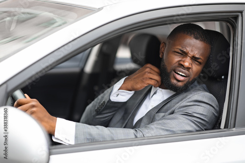 Stressful african businessman untying his shirt while driving car © Prostock-studio