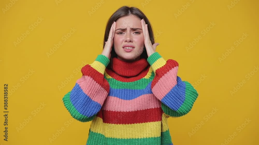 Sick tired upset young woman 20s years old in colorful sweater posing isolated on yellow background studio. People lifestyle concept. Looking camera keep eyes closed put hands on head having headache Sick tired upset young woman 20s years old in colorful sweater posing isolated on yellow background studio. People lifestyle concept. Looking camera keep eyes closed put hands on head having headache