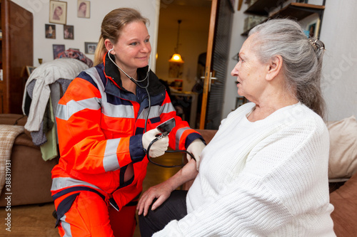 a paramedic measures an old woman's blood pressure