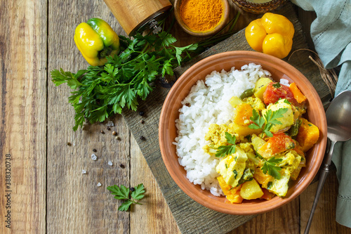 Indian cuisine dish sabji. Traditional Indian vegetable stew with soft cheese and turmeric on a wooden table. Top view flat lay background. Copy space.