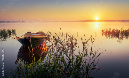 Boat on the lake in the rays of the rising sun and fog, zemborzycki lake