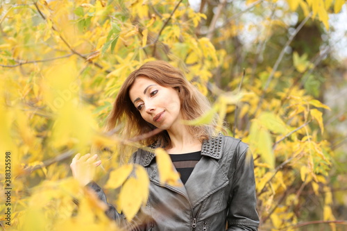 Beautiful woman and yellow leaves in the park in autumn