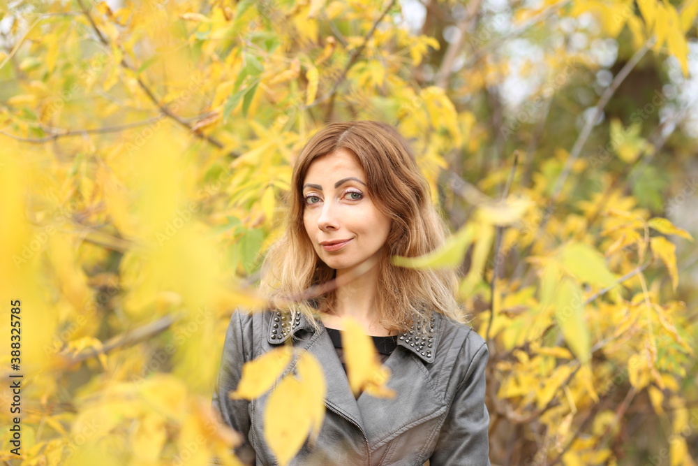 Beautiful woman and yellow leaves in the park in autumn Beautiful woman and yellow leaves in the park in autumn