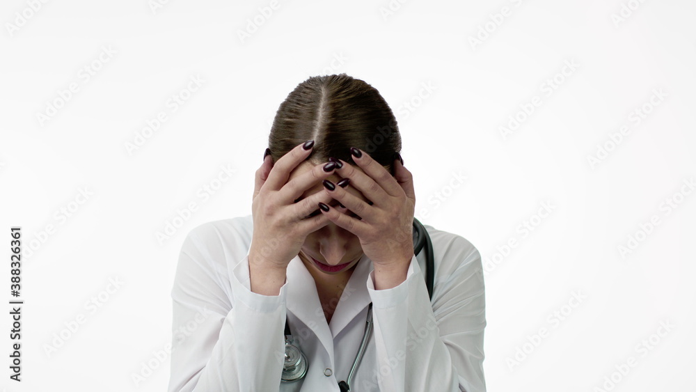 Attractive ill female doctor in medical uniform with migraine headache grabs hands behind head feels tired despair, medical specialist burnout because of overwork. Difficulties at overtime work Attractive ill female doctor in medical uniform with migraine headache grabs hands behind head feels tired despair, medical specialist burnout because of overwork. Difficulties at overtime work