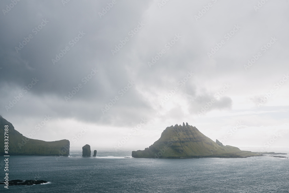 Tindhólmur island, dramatic clouds and strong wind. Vágar, Faroe Islands.