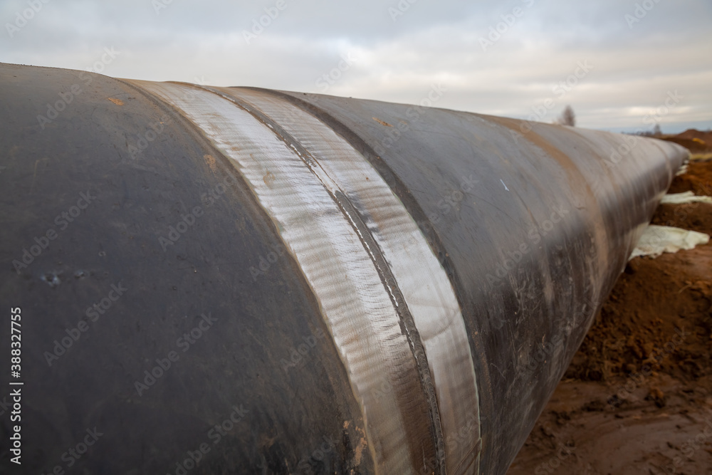 a weld on an oil pipeline. View of the pipeline being assembled in the field. Cloudy day, autumn