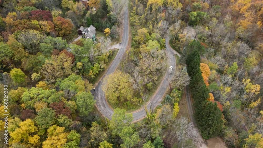 Top down view of a garbage truck driving on a winding road through the forest in La Crosse