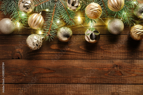 Christmas balls decoration in vintage style and fir tree branches with lights on old wooden background. Flat lay, top view. Christmas greeting card template, postcard design, banner mockup