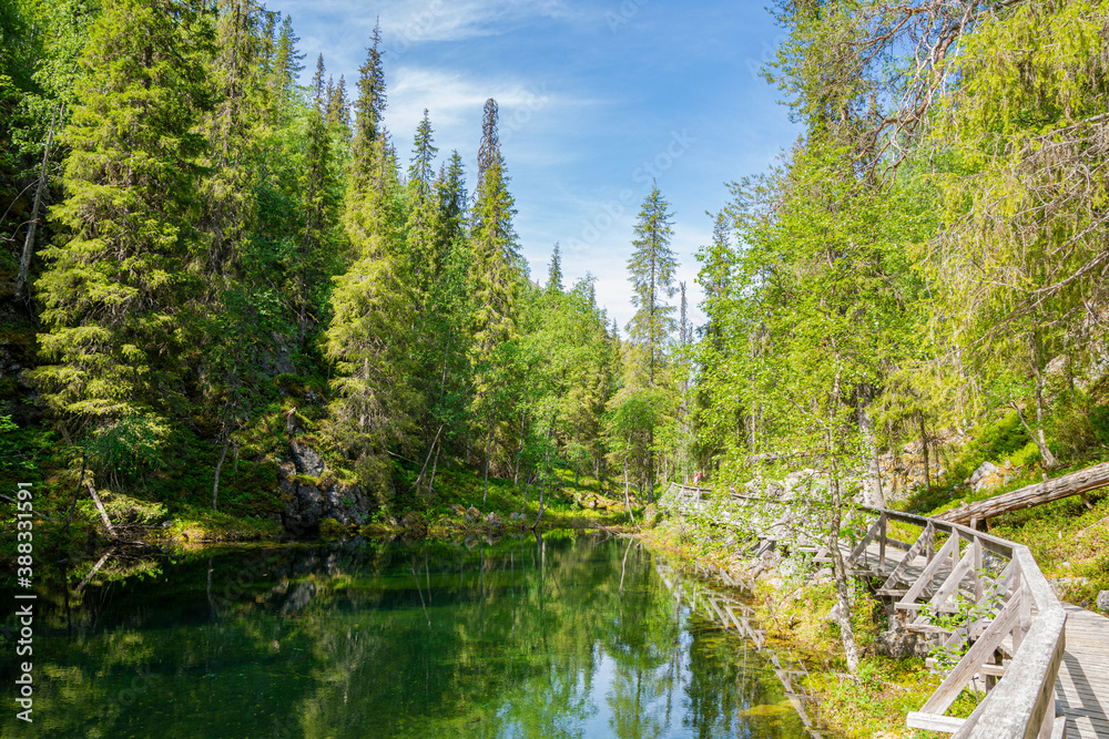 View of The Pyha-Luosto National Park in summer, stones, trees, wooden walkway and natural pond, Lapland, Finland View of The Pyha-Luosto National Park in summer, stones, trees, wooden walkway and natural pond, Lapland, Finland