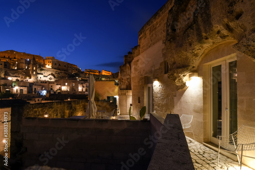 Late night view of the ancient sassi of Matera Italy from an illuminated patio.