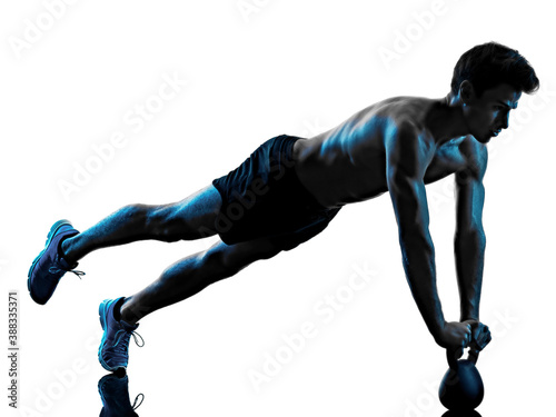 one caucasian young man exercIsing fitness Kettle Bell exercise in studio shadow silhouette isolated on white background