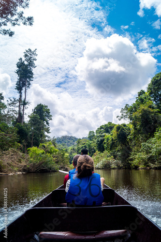 young woman sitting in boat on river in jungle © Denis Feldmann