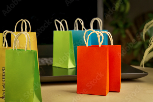 online shopping concept. little deliver boxes, smartphone, shopping bags, shopping bascket stand on laptop. copy space