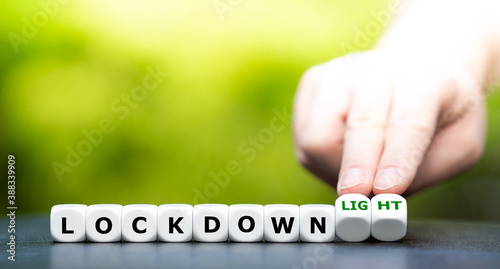 Symbol for a second lockdown. Hand turns dice and changes the expression "lockdown" to "lockdown light".