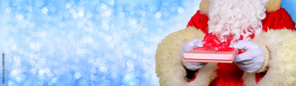 santa claus with white beard in red suit gives a gift in a box, concept of christmas, waiting for gifts, celebrating new year, holiday sales and discounts, nicholas day