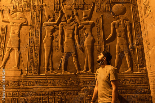 A young man visiting the beautiful temple of Kom Ombo at night, the temple dedicated to the gods Sobek and Horus. In the town of Kom Ombo near Aswer, Egypt. photo