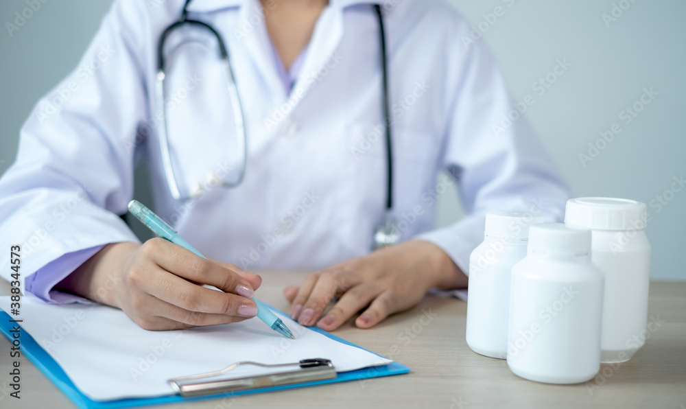 The doctor records the health examination results and medication usage for the patient The doctor records the health examination results and medication usage for the patient
