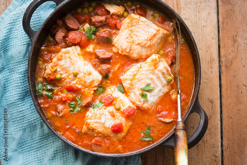 Cod chorizo stew with peas and parsley in tomato sauce 