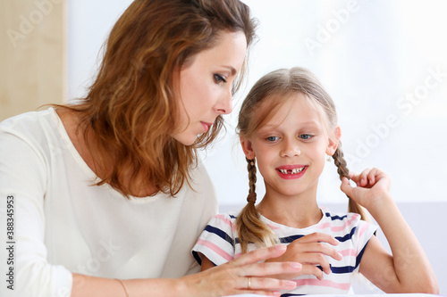 Blond little reading together with mom. Beautiful female young reader, minor baby-sitter, fairy tale joy, story, juvenile development, parent lifestyle, youth concept