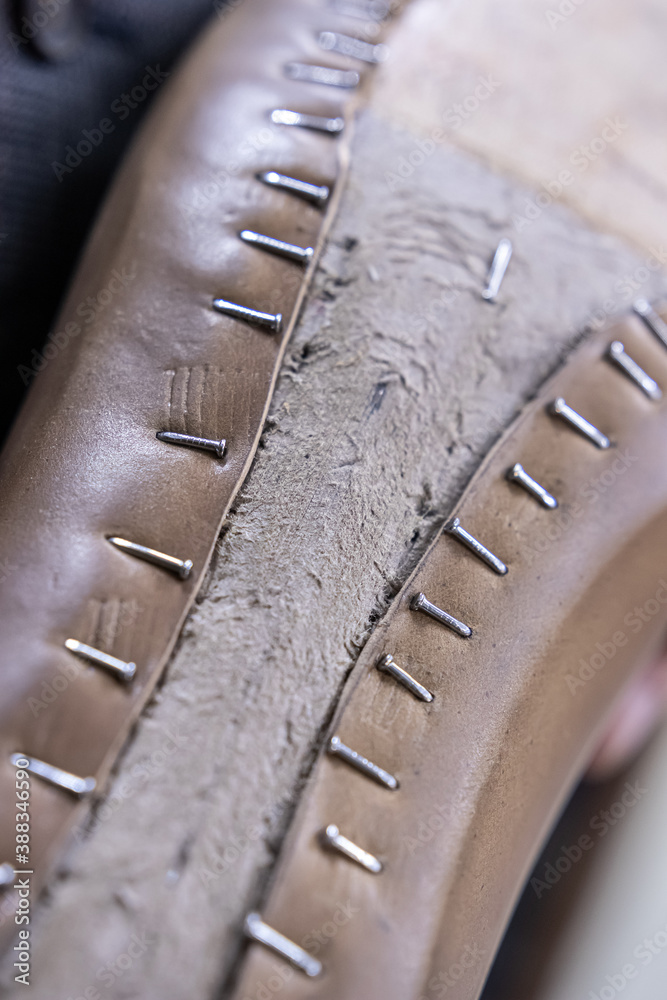 Brown leather cardavan was pulled over a shoe last and the leather was fixed with nails, one of the stages of creating handmade shoes Brown leather cardavan was pulled over a shoe last and the leather was fixed with nails, one of the stages of creating handmade shoes