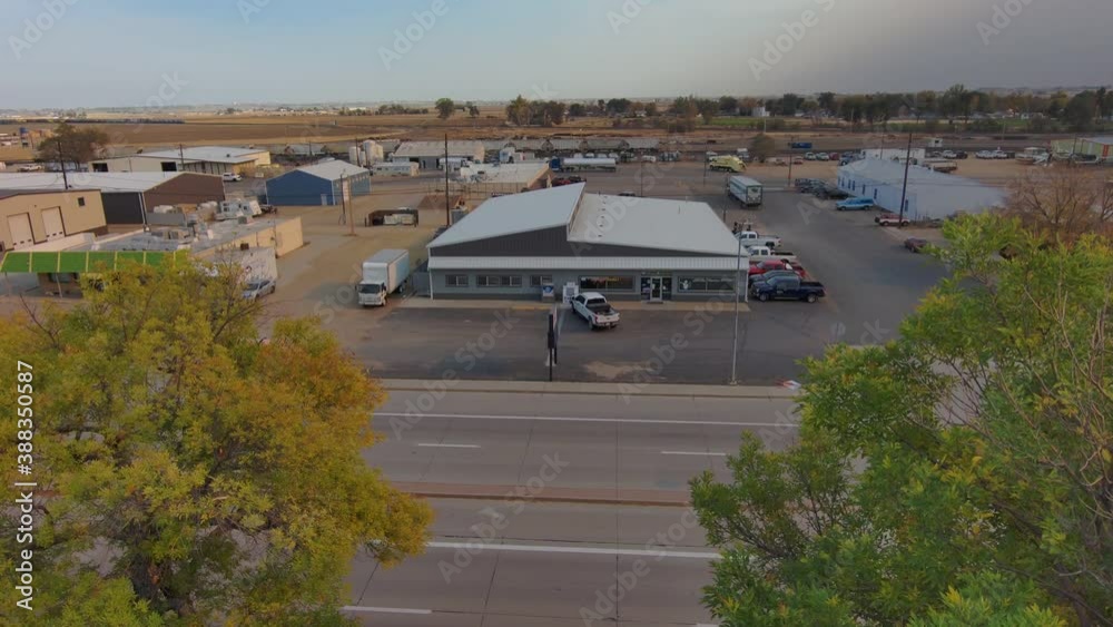 A small industrial park along a busy highway in a small community.  Establishing shot pressing forward through trees.