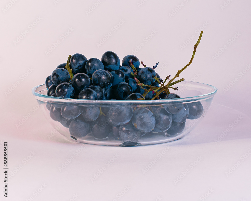 juicy grapes on a white background in a plate on unusual color