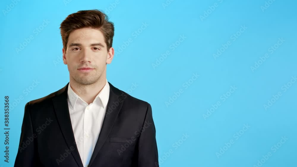 Copy space. Portrait of young successful confident businessman isolated on blue studio background. Man in business suit looking to camera and smiling. Portraiture of handsome guy. Copy space. Portrait of young successful confident businessman isolated on blue studio background. Man in business suit looking to camera and smiling. Portraiture of handsome guy.